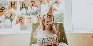 cute young girl enjoying her birthday celebrations in a decorated home environment focus on falling paper confetti space for copy