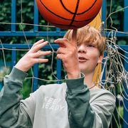 adolescent boy spinning basketball on finger
