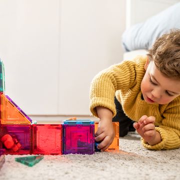 three year old boy playing with magnetic tiles