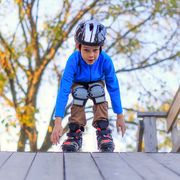 boy roller blading with helmet and knee pads