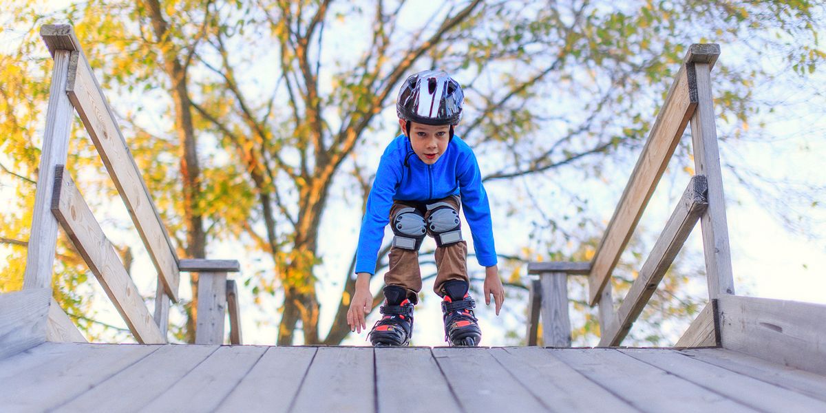 boy roller blading with helmet and knee pads