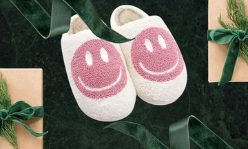 fuzzy smiley face slippers on a holiday background