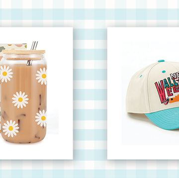 glass iced coffee cup with daisy print and lid with metal straw next to a white baseball cap with blue bill and vintage nba all star weekend print