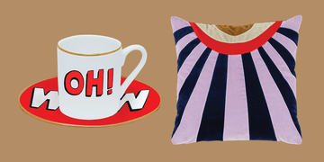 white mug with a saucer and a decorative pillow