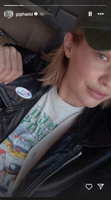 individual showing a voting sticker while wearing a graphic tshirt and a leather jacket