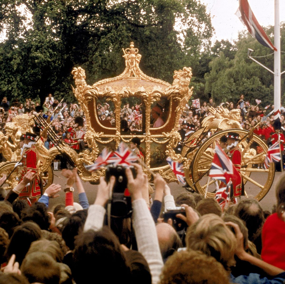 Crowd hailing Queen Elizabeth II in her gilded state coach
