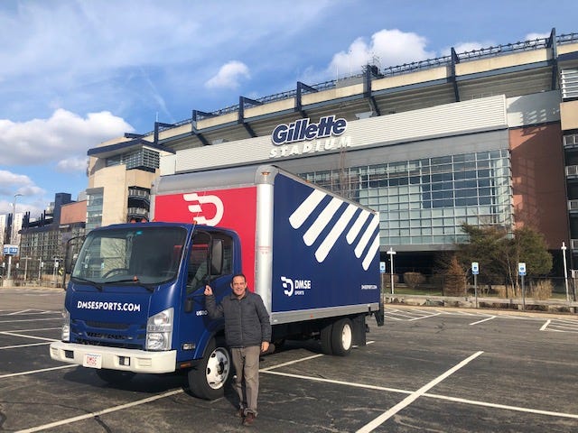 dave mcgillivray stands outside gillette stadium next to a dmse sports truck