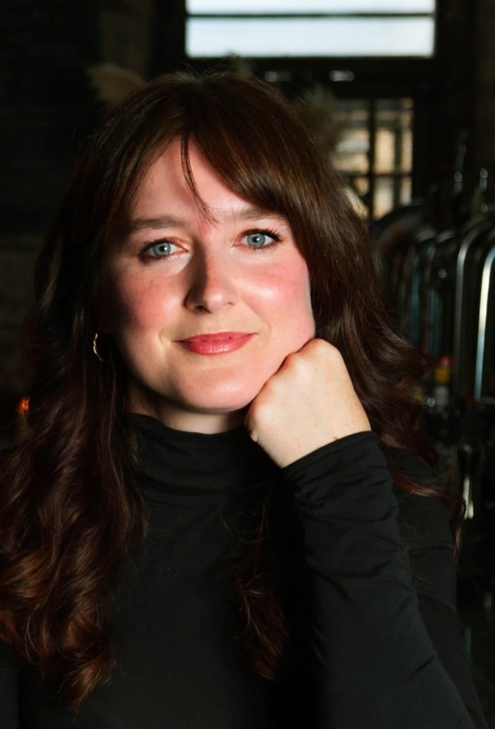 a person with curly hair wearing a black turtleneck