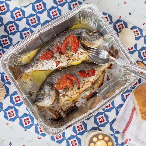 gilt head bream in a baking tray decorated with lemon