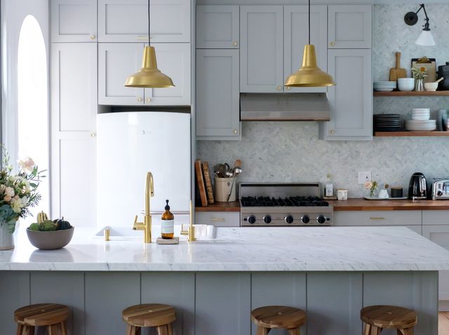 gray and white kitchen with brass pendants