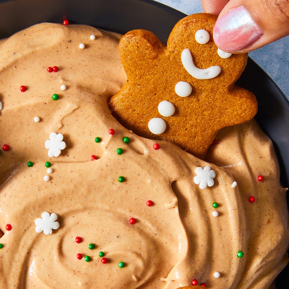 gingerbread flavored cheesecake dip in a bowl topped with sprinkles and gingerbread cookeis