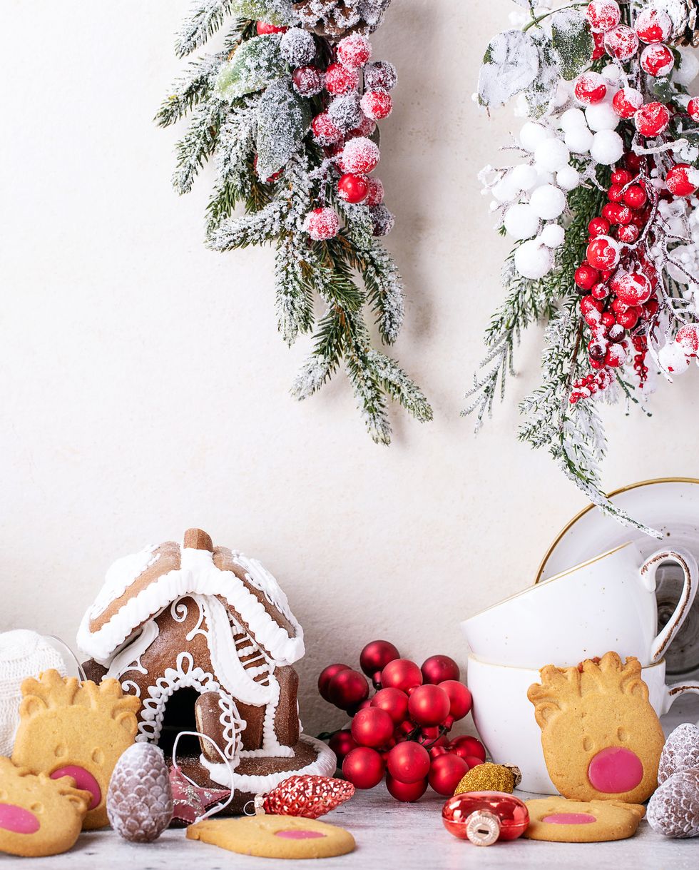 Gingerbread house and Christmas decorations on white wall