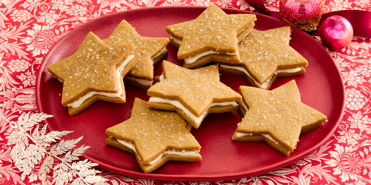 Baked star-shaped gingerbread cookies powdered with sugar for Christmas on  baking parchment paper near pine cones and twigs, dried orange slices and  cinnamon sticks. Flat lay 27025793 Stock Photo at Vecteezy