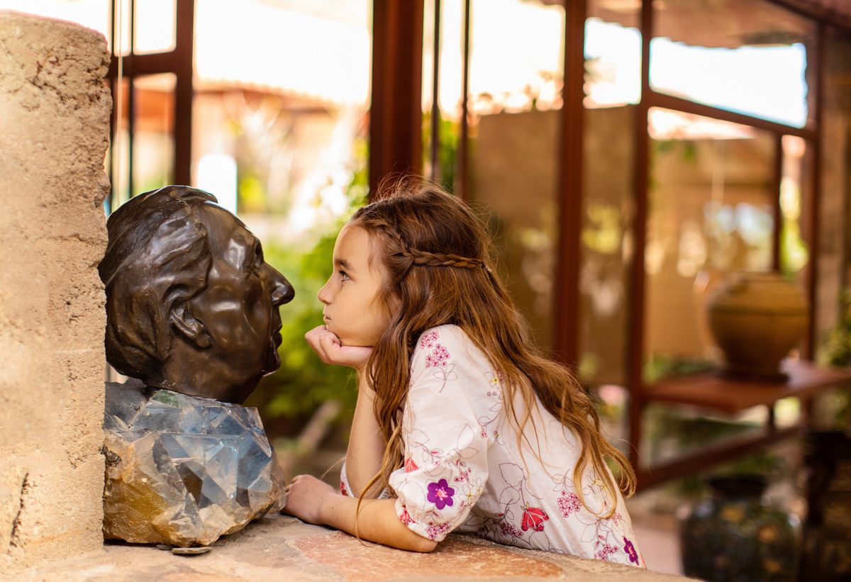 young girl staring closely at Frank Lloyd Wright bust