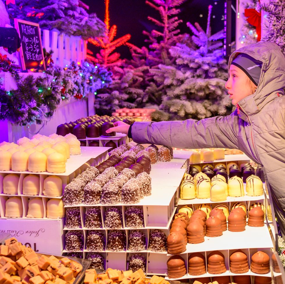 girl buying chocolate in brussels christmas market belgium