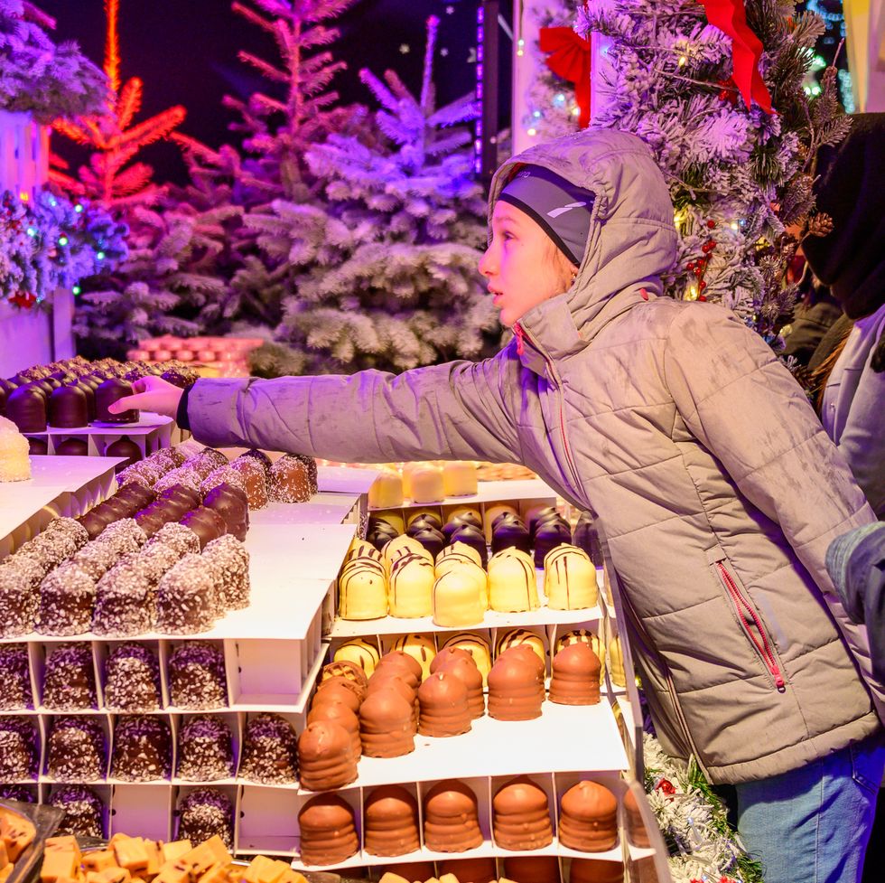 girl buying chocolate in brussels christmas market belgium