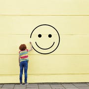 Girl drawing smiley face on to a wall girl drawing smiley face on to a wall