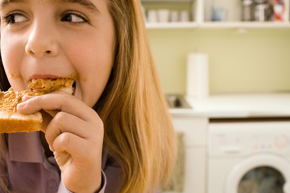 girl eating toast in kitchen