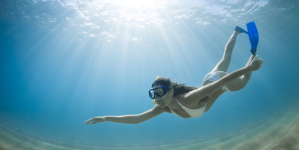 girl gracefully free diving in clear water