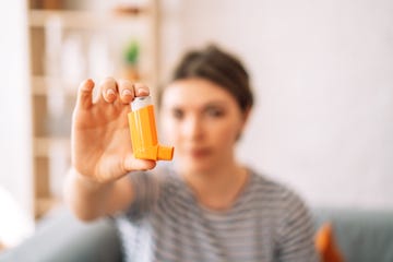 girl holding an inhalation can in her hand