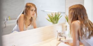 Girl in bathroom looking at mirror
