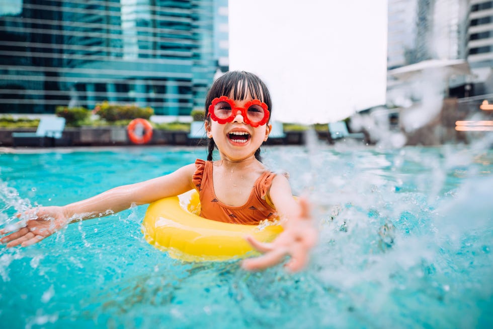 girl with red sunglasses playing the pool with a yellow floaty