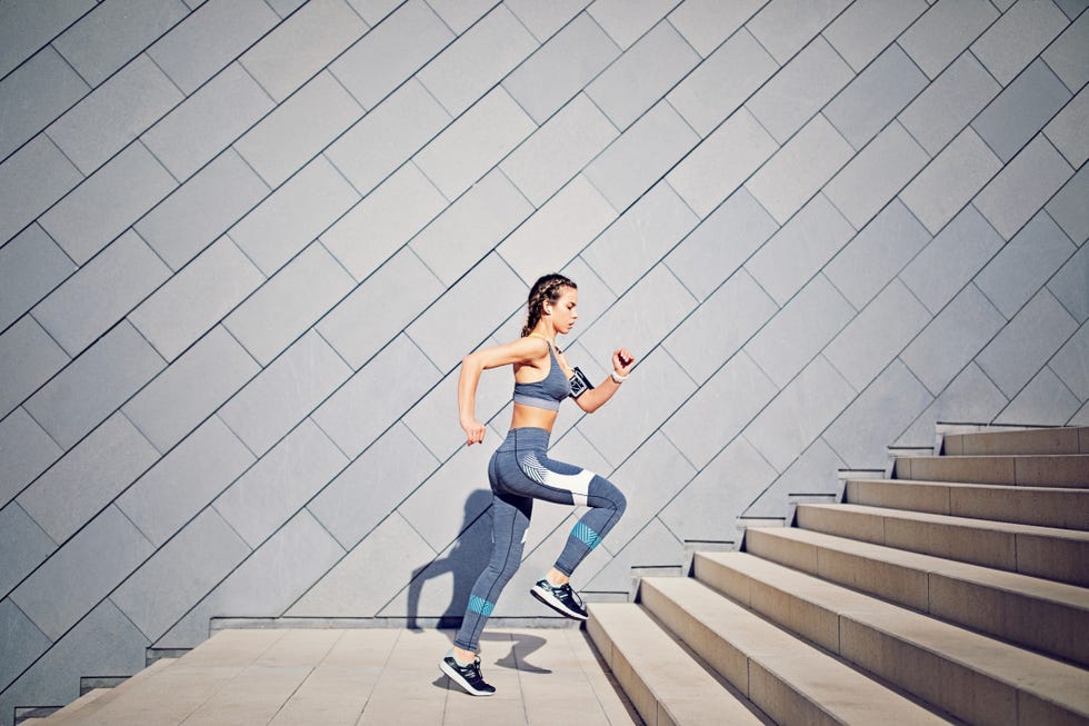 Girl is runing on the city stairs and listening the music