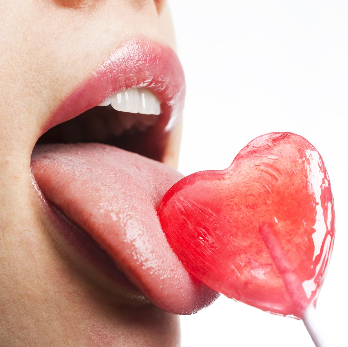 Girl licks heart lollipop