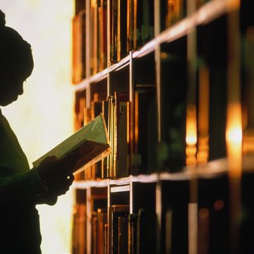 why is black history month in february girl looking at book in library in silhouette
