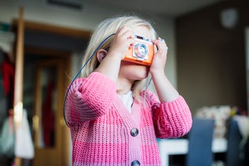 niña con cámara de fotos jugando