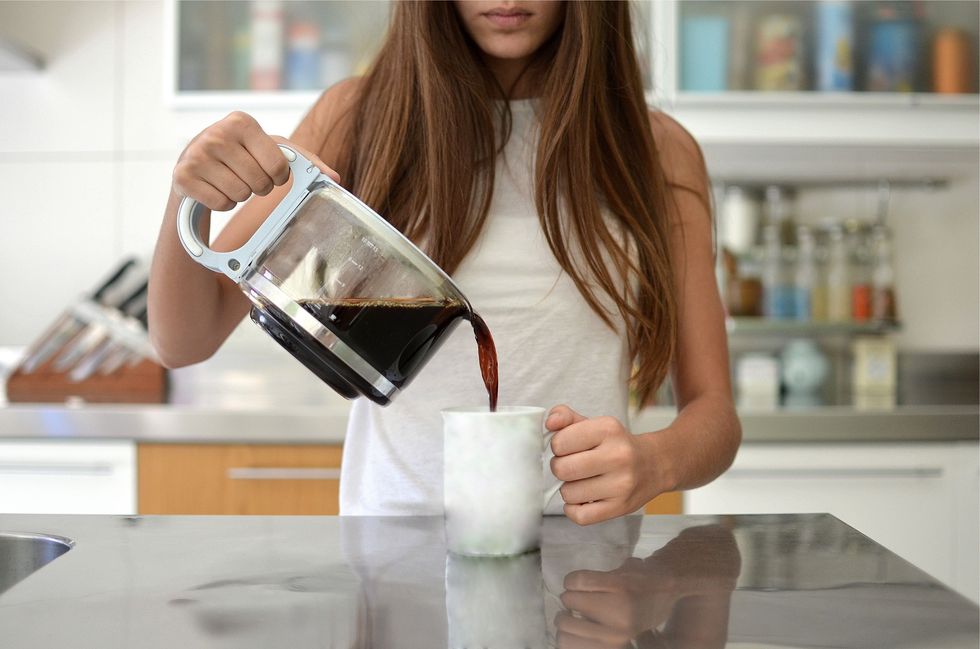 girl pouring a cup of coffee in the kitchen