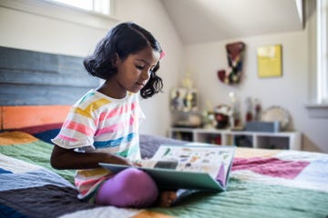 Girl reading book on her bed