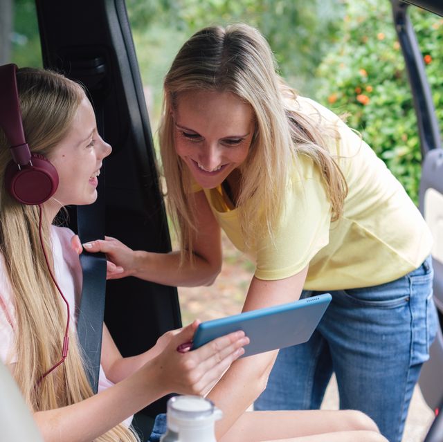 girl shares tablet wonders with mom in the car