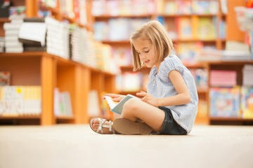 niña en biblioteca leyendo