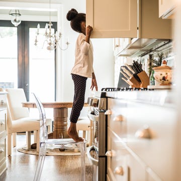 Girl standing on tippy toes looking in cupboard girl standing on tippy toes looking in cupboard