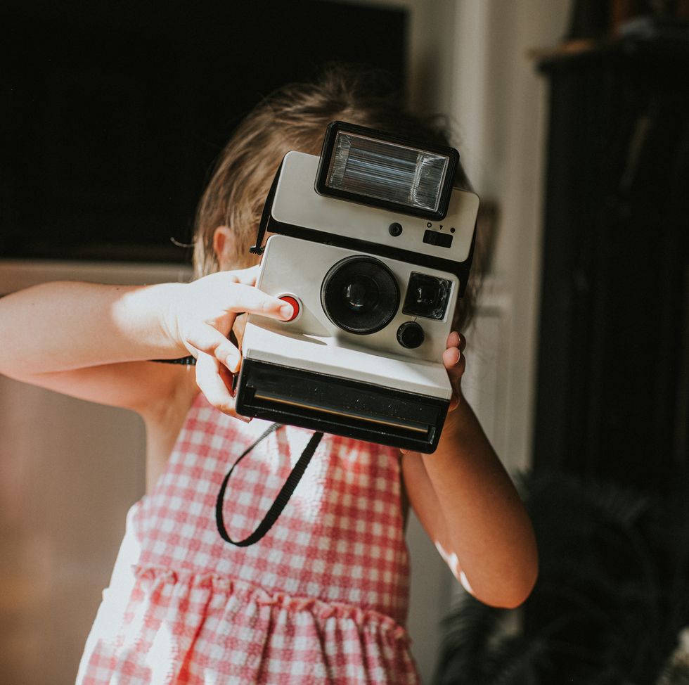 girl taking an image with an instant camera