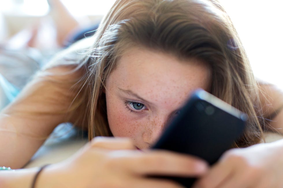 niña usando un teléfono móvil
