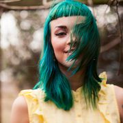 girl with green hair blowing over her face