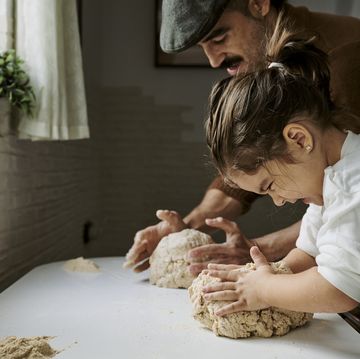 girl with her father making strength while kneading bread