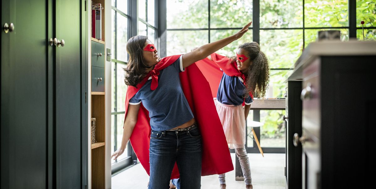 girl with mother in red superhero costume at home