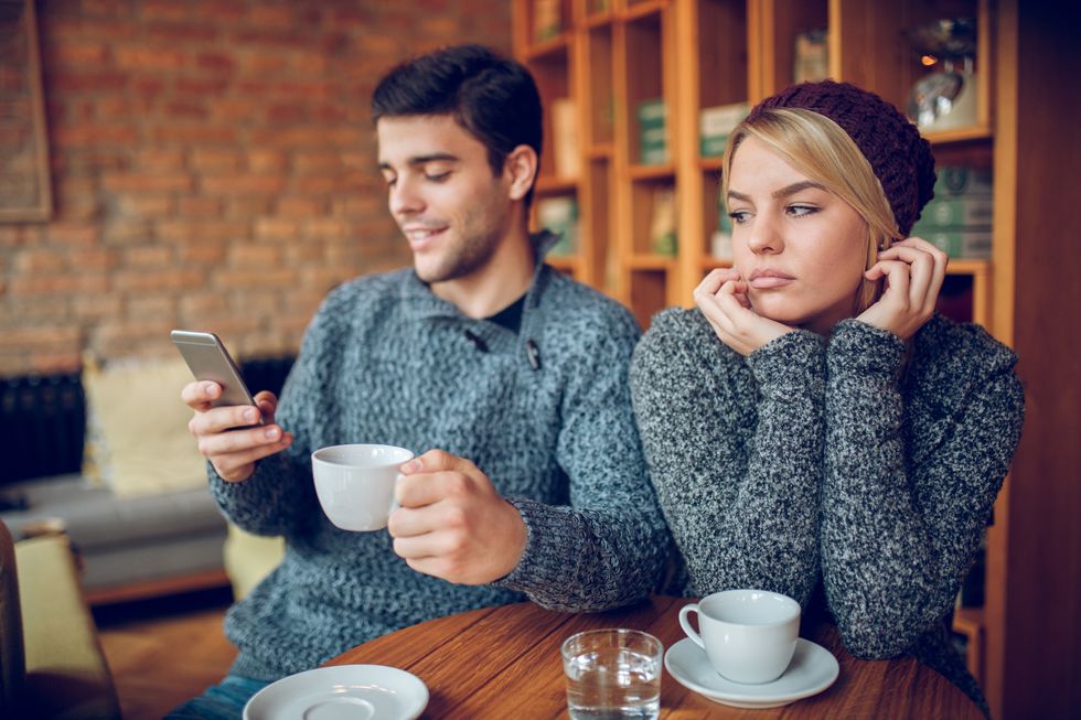 Girlfriend displeased with boyfriend using mobile phone during date.