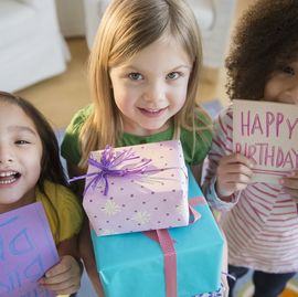 girls holding presents and cards at birthday party