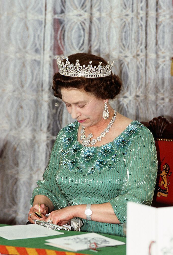 kenya   january 01  queen elizabeth ii looks through her handbag during a banquet in kenya  photo by tim graham photo library via getty images