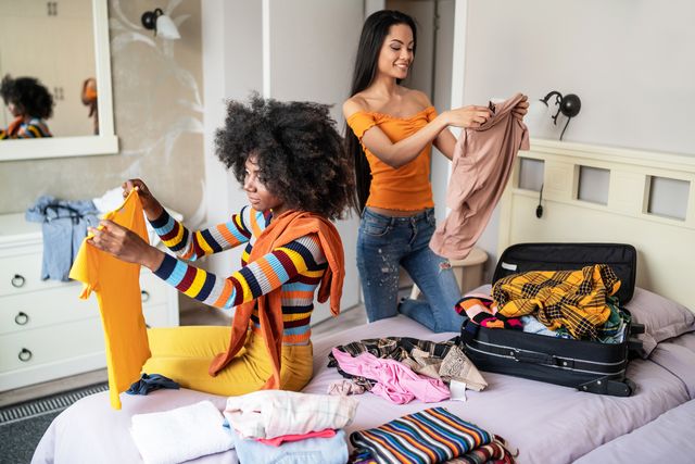 Girls packing clothes in suitcase for travel