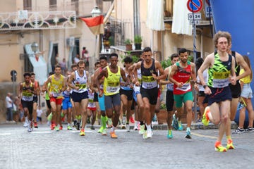 athletes participating in a running competition on a cobblestone street