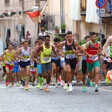 athletes participating in a running competition on a cobblestone street athletes participating in a running competition on a cobblestone street