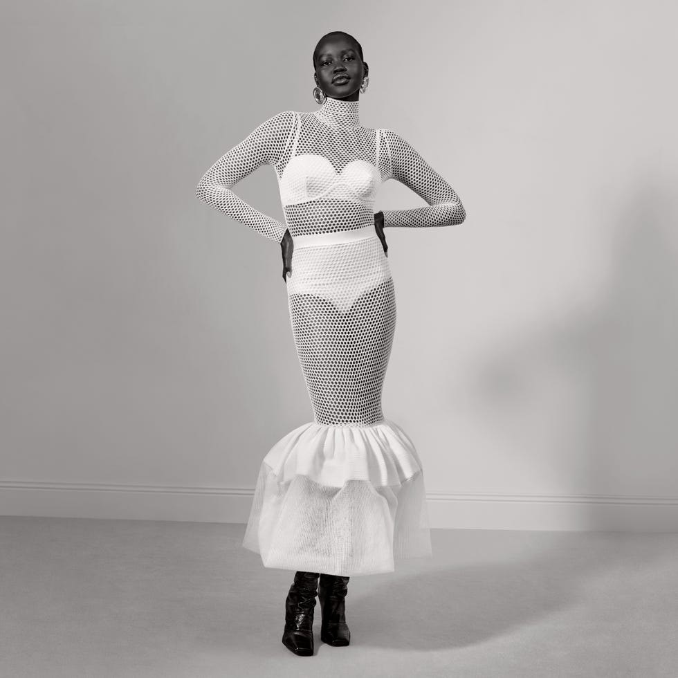 fashion model wearing a unique white mesh dress with a dramatic flared skirt