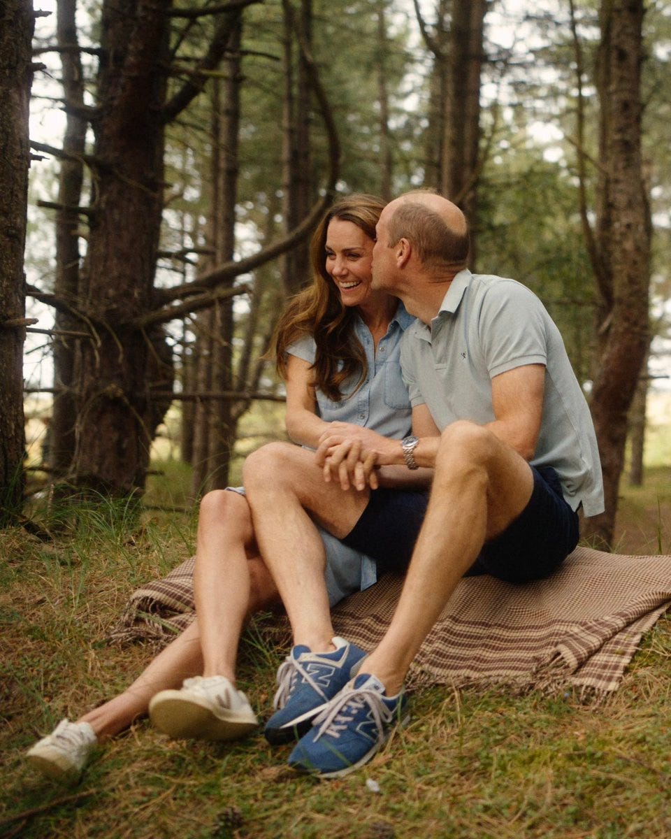 couple sitting closely together outdoors in a wooded area