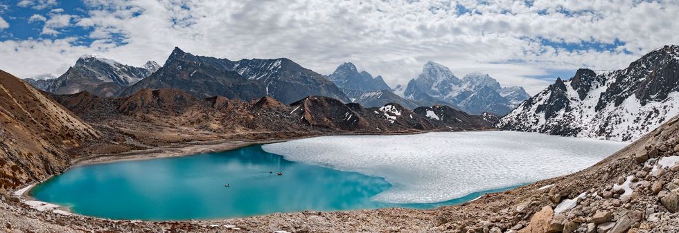 De onderzoekers varen over het Tabochemeer Het is mei het water oppervlak is grotendeels bevroren Taboche en de andere meren in Khumbu Nepal zijn belangrijkvoor de lokale bevolking Maar sommige meren vormen een bedreiging voor lager gelegen dorpen als ze over hun natuurlijke dammen spoelen of als deze doorbreken