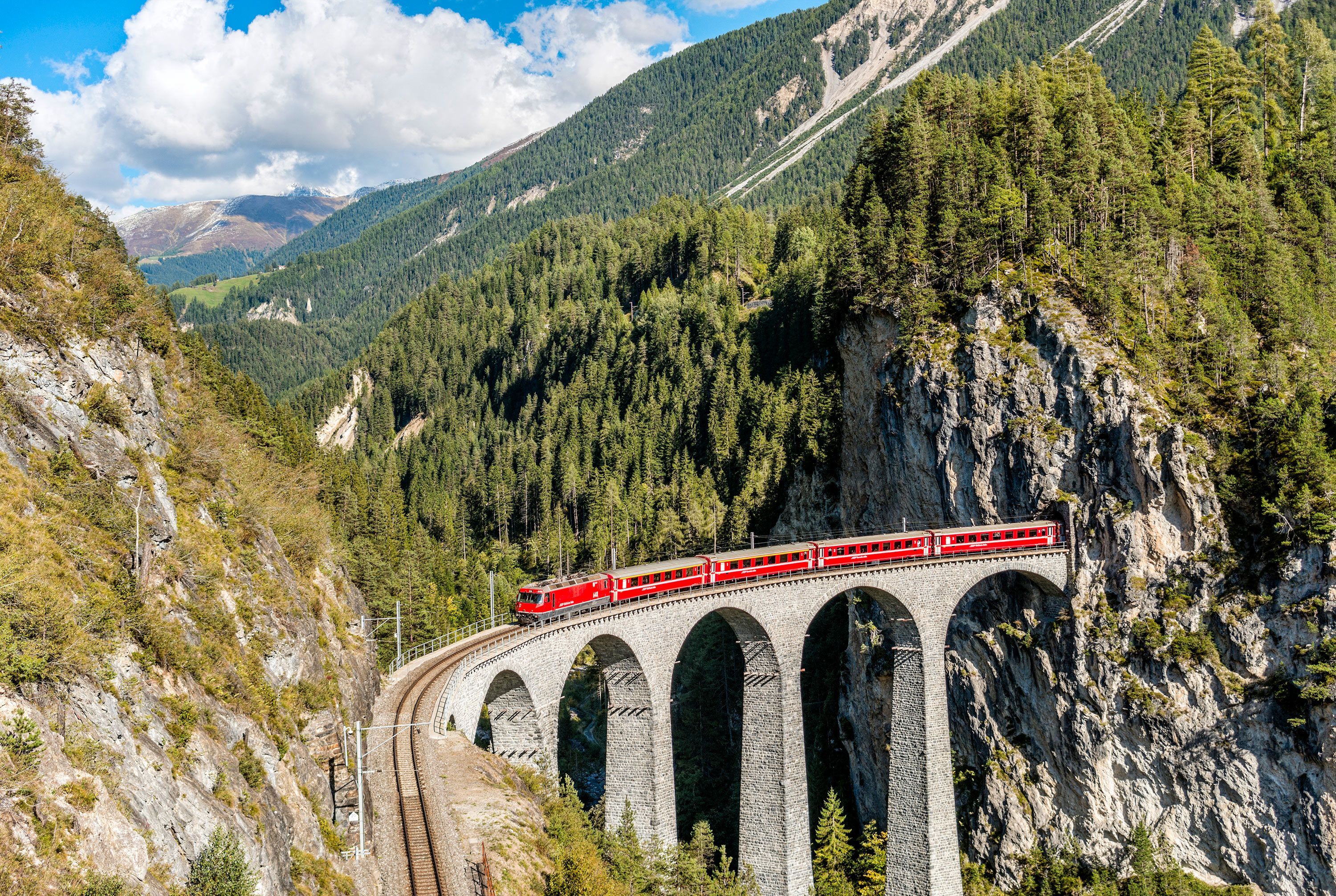 De Glacier Express destilleert het Alpengevoel tot acht reisuren vol besneeuwde bergen Alpenweiden en pittoreske bergdorpjes tussen Zermatt en Sankt Moritz in Zwitserland